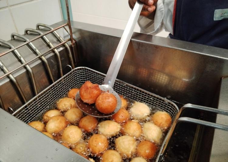 Beignets en train de cuire dans une friteuse dans la cuisine du restaurant de Prélude